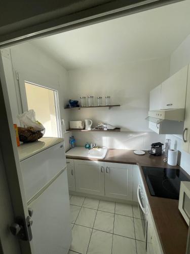 une cuisine avec des armoires blanches et un évier dans l'établissement APT CHATELAILLON - 6 people -PLAGE CASINO, à Châtelaillon-Plage