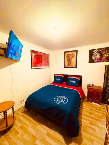 une chambre avec un lit et une télévision dans l'établissement Jolie chambre à Nanterre Préfecture proche La Défense Aréna Campus SNCF et Paris, à Nanterre