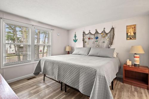 una camera con un grande letto e due finestre di Counting Corks - Waterfront, Pet friendly, private dock! a Eastville
