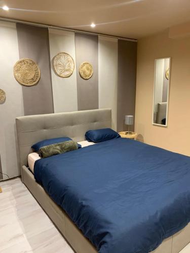 une chambre avec un grand lit avec des draps et des oreillers bleus dans l'établissement Montmartre Shelter, à Paris