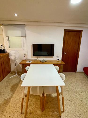 a living room with a white table and a tv at Sol y playa in Puerto de Sagunto