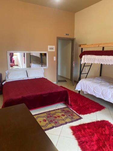 a room with two beds and red rugs at Κτήμα ΓΟΥΡΔΟΎΠΗ Georgιο in Lalióti