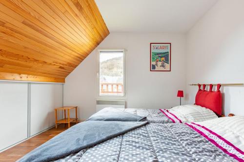 une chambre avec un grand lit avec un plafond en bois dans l'établissement Appartement duplex classé 4 étoiles plein centre village, à Saint-Lary-Soulan