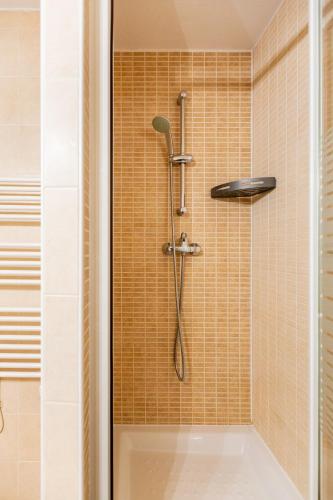 une douche avec pommeau de douche dans une salle de bain dans l'établissement Appartement duplex classé 4 étoiles plein centre village, à Saint-Lary-Soulan