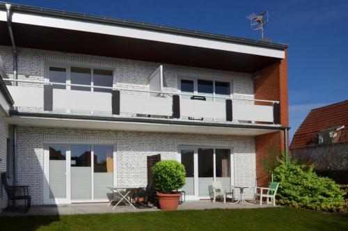 ein Haus mit weißen Balkonen und einer Terrasse in der Unterkunft Seerose Koki in Kellenhusen