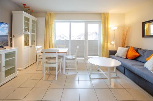 ein Wohnzimmer mit einer Couch und einem Tisch in der Unterkunft Seerose Koki in Kellenhusen