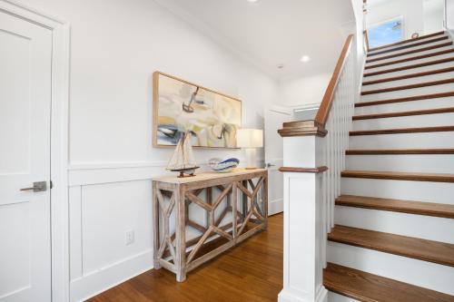 a staircase in a home with white walls and wooden floors at Day Dream Believer - New Construction, Upscale Resort, Many Amenities! in Cape Charles