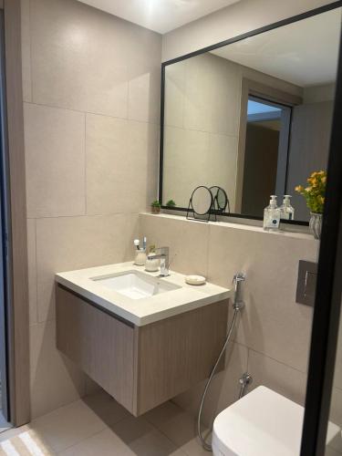 a bathroom with a sink and a mirror and a toilet at Families Only, 1BR Aprt,Beach Access,Garden View in Amwaj Island