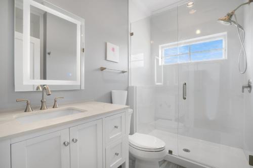 a white bathroom with a sink and a shower at Day Dream Believer - New Construction, Upscale Resort, Many Amenities! in Cape Charles