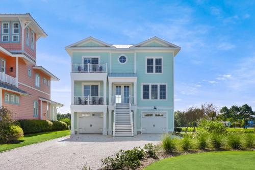 a blue house with two garage at Day Dream Believer - New Construction, Upscale Resort, Many Amenities! in Cape Charles