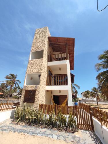 a building on the beach with palm trees at Maluhia Lofts in Icaraí