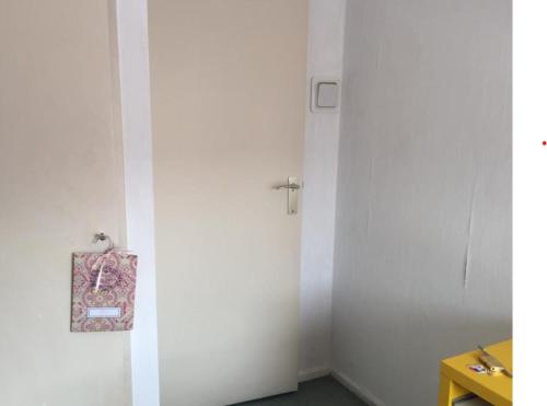 a white room with a door with a bag on it at De Deken in Best
