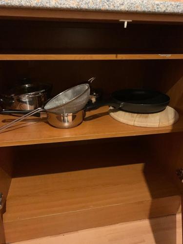 a shelf with pots and pans in a cabinet at Your home 10 with parking in Košice