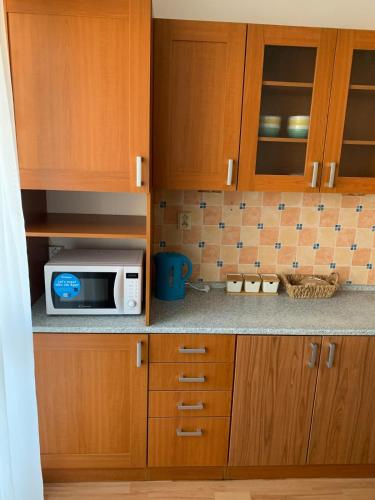 a kitchen with wooden cabinets and a microwave at Your home 10 with parking in Košice