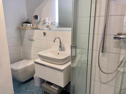a bathroom with a sink and a shower and a toilet at Amselnest in Wyk auf Föhr