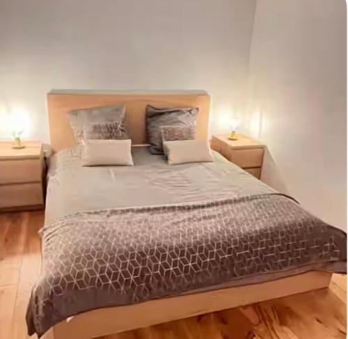 une chambre avec un grand lit avec deux tables de nuit dans l'établissement Studio cosy indépendant Centre ville-Quartier facultés, à Nantes