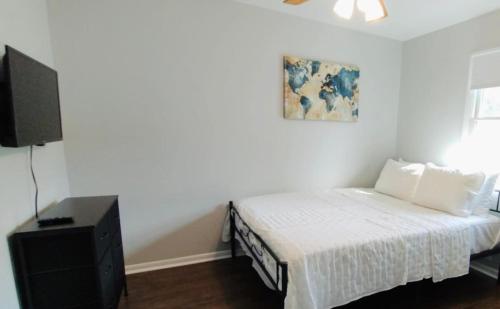 a bedroom with a bed and a flat screen tv at Private Upstairs Unit near Balt City John Hopkins in Baltimore