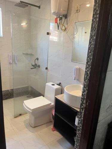 une salle de bain avec toilettes, douche et lavabo dans l'établissement Eraya Boutique stays, à Chhatikara