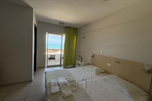 a bedroom with a large white bed with a view of the ocean at MoviHosts Terrazzo in Natal