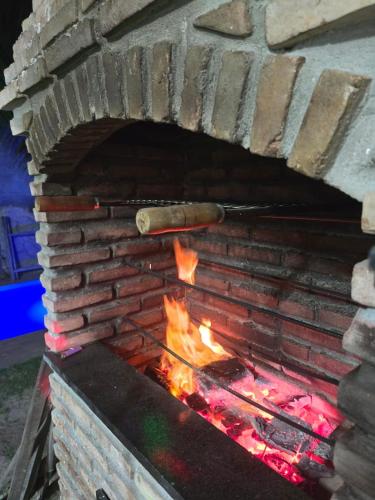 a brick oven with fire inside of it at Quarto casal ventilador in Conde