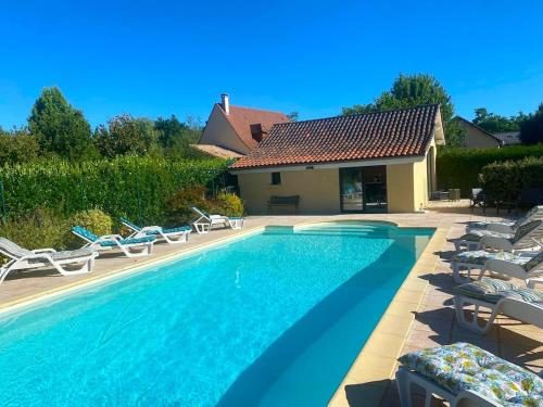 une piscine avec des chaises longues et une maison dans l'établissement Proprieté 6 Chambres en Périgord, à Saint-Julien-de-Lampon