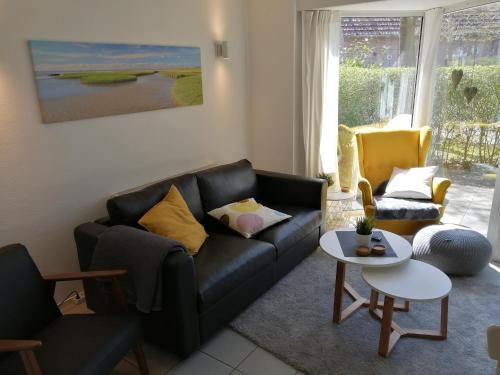 a living room with a black couch and a table at Ferienhaus 2004 in Tossens in Tossenserdeich