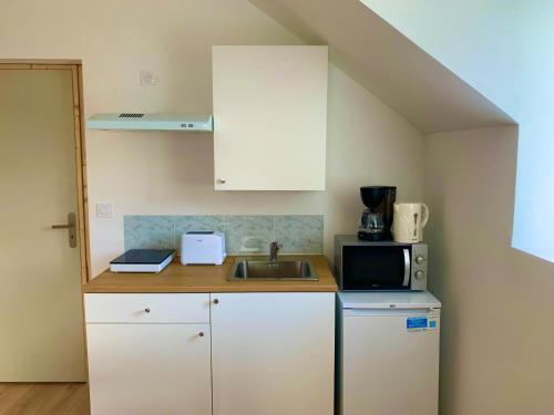 a small kitchen with a sink and a microwave at Studio guingamp in Guingamp