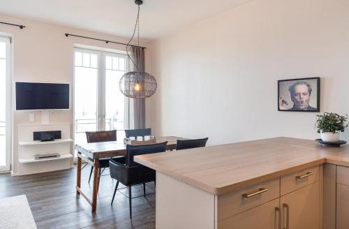 a kitchen and dining room with a table and a dining room at Strand Residenz Amrum Strandhaus 6 in Wittdün