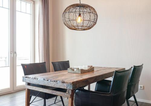 a dining room table with chairs and a chandelier at Strand Residenz Amrum Strandhaus 6 in Wittdün