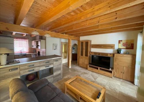 a living room with a couch and a kitchen at Ferienhaus Stefanie in Bernbeuren