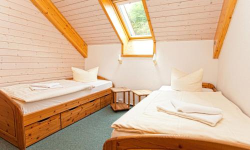 two beds in a small room with a window at Ferienhaus Nr 3 Sporthotel Oberhof in Oberhof