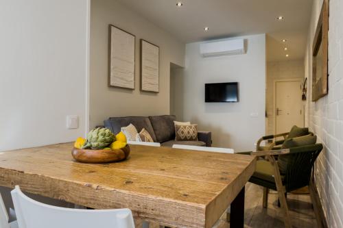 a living room with a table with a bowl of fruit at Novus Homes Barcelona Santa Eulalia in Hospitalet de Llobregat