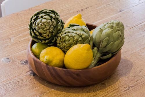 a wooden bowl of fruits and vegetables on a table at Novus Homes Barcelona Santa Eulalia in Hospitalet de Llobregat