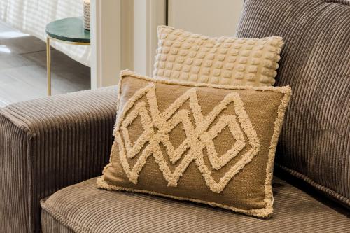 a brown pillow sitting on a couch in a living room at Novus Homes Barcelona Santa Eulalia in Hospitalet de Llobregat