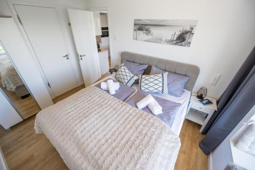 a bedroom with a large bed with two pillows at FeWo Prora - Wellenblick inklusive Strandkorb in Binz