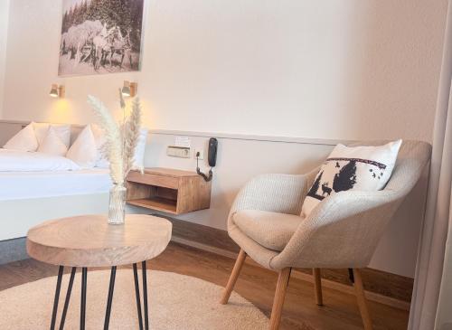 a living room with a chair and a table at Landgasthof Jostalstüble in Titisee-Neustadt