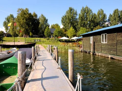 a dock with a boat and a building on the water at Ferienwohnung, Röbel an der Müritz in Röbel
