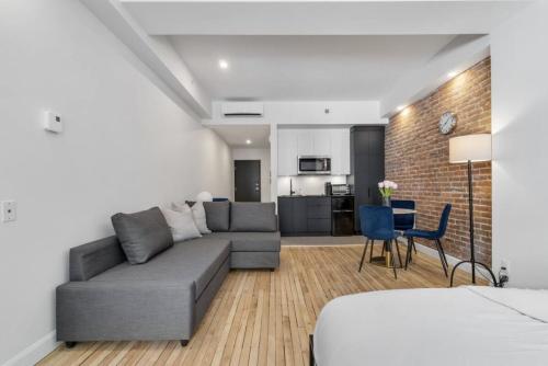 un salon avec un canapé et une cuisine dans l'établissement Initial / Suite trésor / Centre-Ville de Québec, à Québec