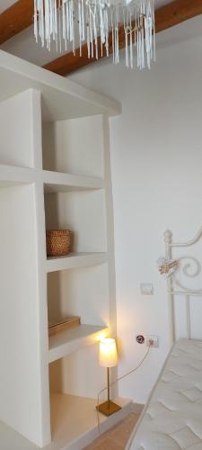 a room with a bed and a chandelier at Aegean Breeze in DYO CHORIA TINOS in Triandáros