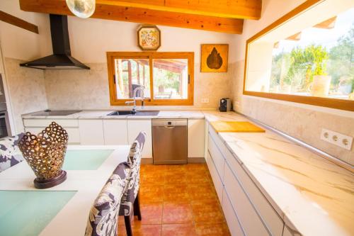 una cucina con mobili bianchi e una finestra di Cas Mostatxet-Wonderful villa with pool a Ballerics