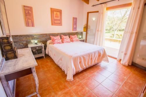 una camera da letto con un letto con cuscini rosa di Cas Mostatxet-Wonderful villa with pool a Ballerics