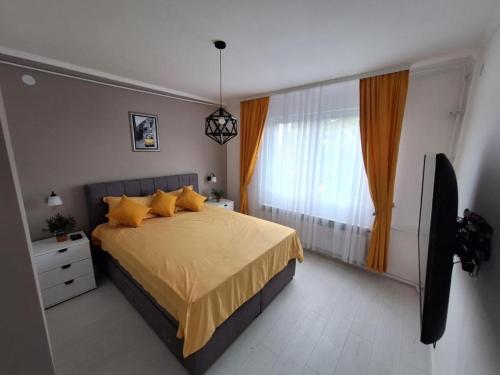 a bedroom with a large bed with yellow pillows at Apartman Nikola Vukosavljevic in Kruševac