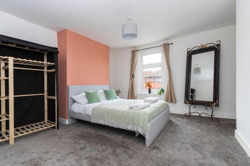 Un dormitorio con una cama y un espejo grande. en The Cozy Terrace, en Guisborough
