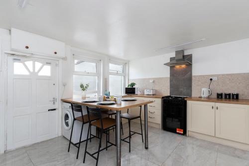 a white kitchen with a table and a stove at The Cozy Terrace in Guisborough