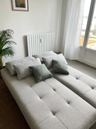 - un grand canapé blanc dans une chambre avec fenêtre dans l'établissement Le sourire Saint-cyrien, à Saint-Cyr-lʼÉcole