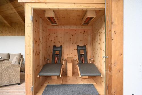 two chairs and a table in a wooden room at Apartment Zugspitze in Biberwier