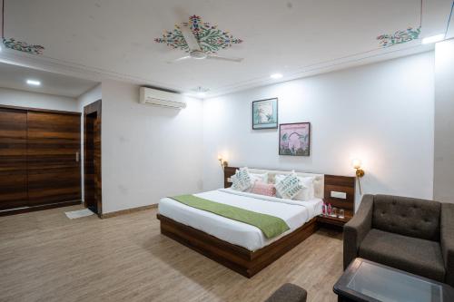 a hotel room with a bed and a chair at Rawla Udaipur - A Unit of UBEO HOTELS in Udaipur