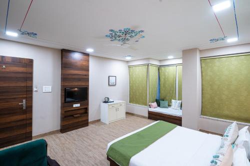 a hotel room with a bed and a television at Rawla Udaipur - A Unit of UBEO HOTELS in Udaipur