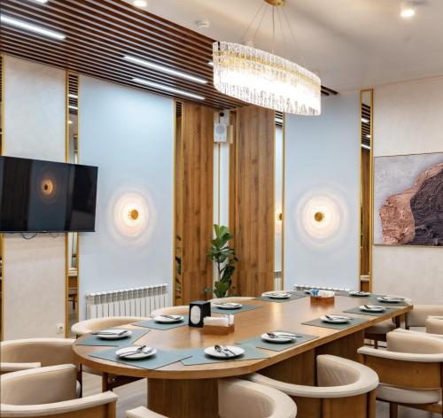 a conference room with a long table and chairs at Apartments in Comfort city 142, Almaty in Almaty