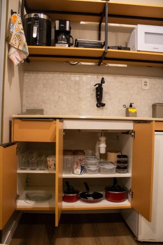 a kitchen cabinet with food items in it at Suíte Aconchego 1 in Macapá